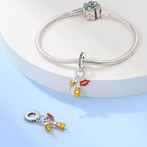 Macro shot of silver beer mug and red lips charms on a classic snake chain bracelet
