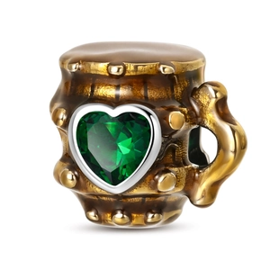 Vintage silver beer barrel charm with a heart-shaped green gemstone and stud details