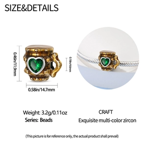 Macro view of a beer stein bead charm with brown glaze and a green heart zircon stone