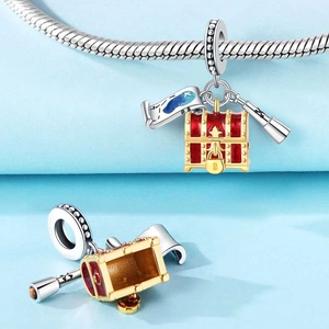 Detailed trio charm featuring a red treasure chest, nautical map, and silver telescope