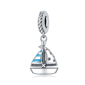Detailed view of silver sailing boat charm with blue stripes and sparkling gemstone
