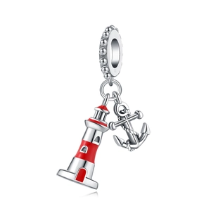 Macro detail of silver nautical lighthouse and anchor charms with red enamel coating
