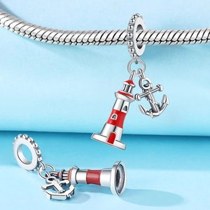Detail showing silver nautical charms with red enamel lighthouse and anchor on a snake chain