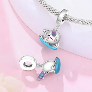Macro view of narwhal charm charms with blue enamel and silver plated copper detail