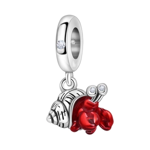 Macro shot of silver seashell and red enamel hermit crab charm with cubic zirconia