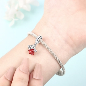 Detail of silver mesh bracelet with red crab charm and sparkling zircon accents