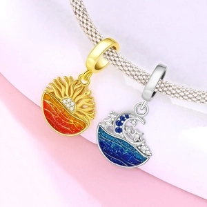Macro shot of sun and moon ocean charms with enamel and colorful zircons on a silver bracelet