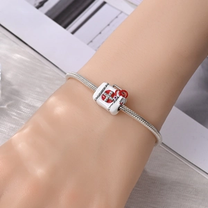 Detailopname van zilveren slangenketting armband met medische witte medicijnkist bedel