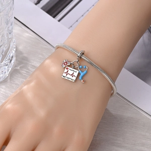 Detail van de verpleegsterbedeltjes met stethoscoop en hartslag op een slangenarmband