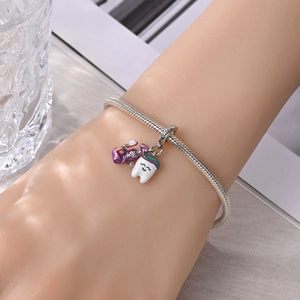 Detail van zilveren slangenketting armband met paarse tandpasta en witte tandbedels