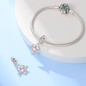 Detail van verpleegsterbedeltjes met roze hart en klavertje op een zilveren slangenketting