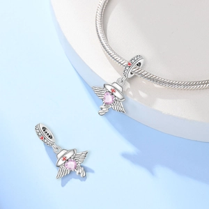 Detail van zilveren verpleegster-bedel met roze hart en rood kruis voor armbanden