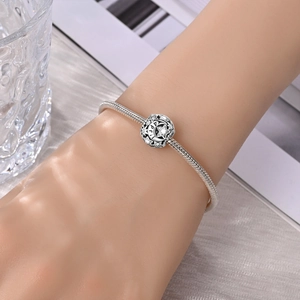 Makroaufnahme von Silber-Charm mit Sternen, Mond und April-Gravur auf einer Schlangenkette