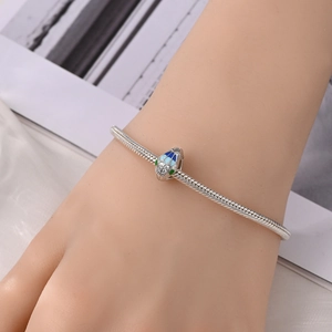 Detail van zilveren slangenarmband met blauwe emaille slangenhanger en fonkelende zirkoon