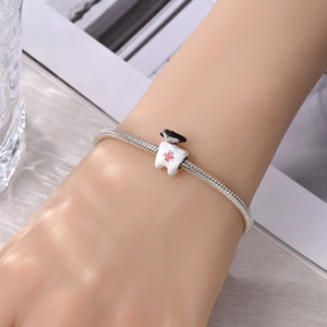 Detail van de zilveren slangenarmband met medische tandbedel gedragen om de pols