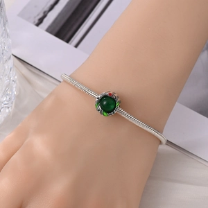Detail van de zilveren slangenhanger met groene edelsteen en email op een armband