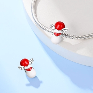 Detail van zilveren hart vleugel capsule bedel met rood emaille op slangenarmband