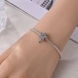 Dettaglio del bracciale con ciondolo a stella in argento e pietre blu con zircone giallo