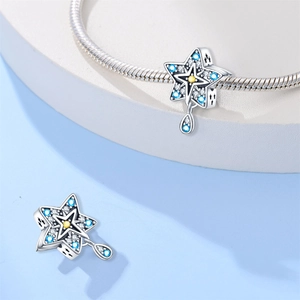 Dettaglio charm stella in argento con zirconi blu e gialli su bracciale a maglia serpente