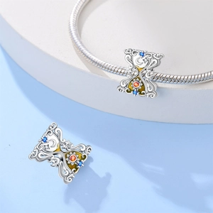 Dettaglio macro dello charm a clessidra dei tarocchi con motivi di sole e luna sul bracciale