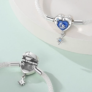 Macro detail of S925 sterling silver heart clasp with blue starry moon and star engraving