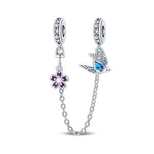 Macro shot of silver safety chain with blue bird and purple enamel flower charms