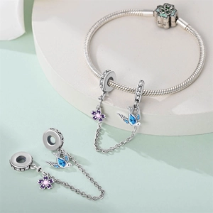 Detail of silver safety chain bead with swallow bird and flower pendants for DIY bracelets
