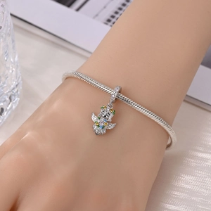 Macro shot of silver snake chain bracelet with a colorful gemstone fairy pendant