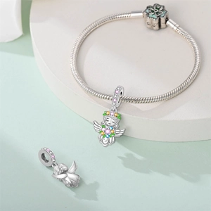 Detail of silver snake chain bracelet featuring a colorful angel charm with floral motifs