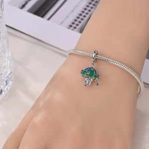 Macro shot of silver snake chain bracelet featuring a colorful enamel umbrella charm