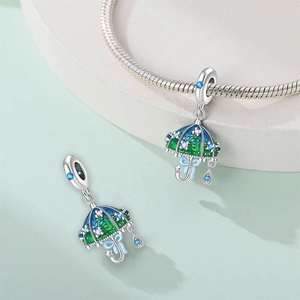 Detail of silver umbrella charms with colorful enamel and blue gemstone drops