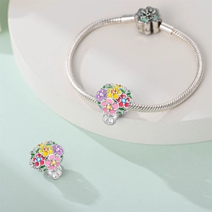 Detail view of silver snake chain bracelet with colorful enamel floral charms and stone accents