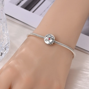 Makro-Detail von silbernem Schlangenarmband mit Herz-Schwester-Anhänger und Gravur