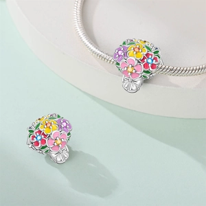 Macro detail of silver floral charm with colorful enamel flowers and tiny zircon stones