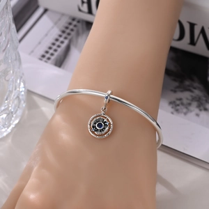 Close-up of silver charm bracelet with blue stone and Love Heart engraving