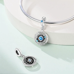 Close-up of rotatable silver charm with blue stone and heart universe engraving