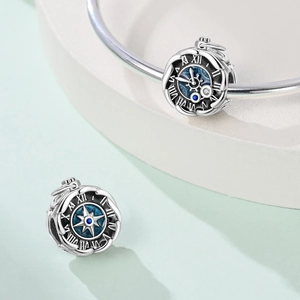 Detailed view of silver clock charm with Roman numerals and blue gemstone for DIY bracelets