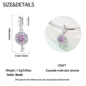 Detailed view of silver key and clock charm with purple zircon for DIY bracelets