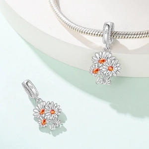 Macro shot of silver daisy flower charm with amber zircon and love engraving on chain