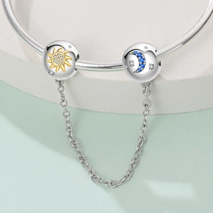 Detail of silver safety chain with celestial sun and moon charms on a beaded bracelet