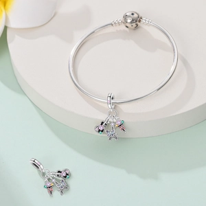 Detail of silver snake chain bracelet with Eiffel Tower and enamel butterfly charms