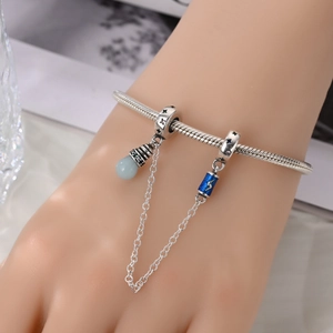 Baroque silver snake chain bracelet with blue enamel charms and safety chain detail