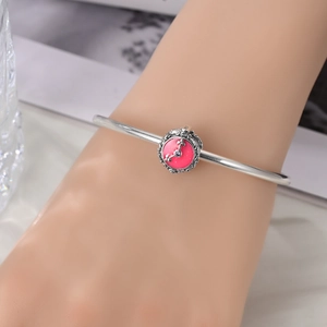 Close-up of S925 silver bracelet with vintage pink enamel bead and clock design
