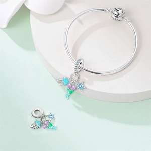 Dettaglio macro del ciondolo sirena in argento con smalto blu e zircone su bracciale