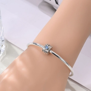 Nahaufnahme eines Silberarmbands mit Evil Eye Anhänger, blauem Stein und Stern-Mond-Gravur