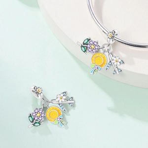 Detailed view of S925 silver charms with cocktail, sun, and airplane pendants on a bracelet