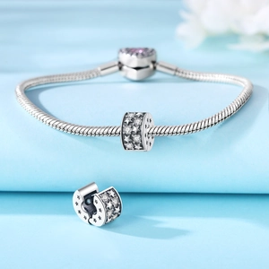 Detalle de pulsera de cadena de serpiente de plata con cierre de corazón y amuleto de estrella
