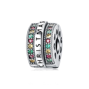 Dettaglio macro dello charm natalizio con gemme multicolori e motivi a cuore traforati