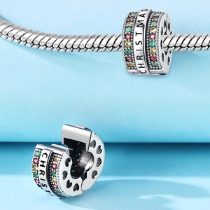 Charm natalizio scintillante con pietre colorate e cuori traforati su una catena
