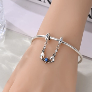 Dettaglio della catena di sicurezza sole e luna su bracciale in argento con pietre blu